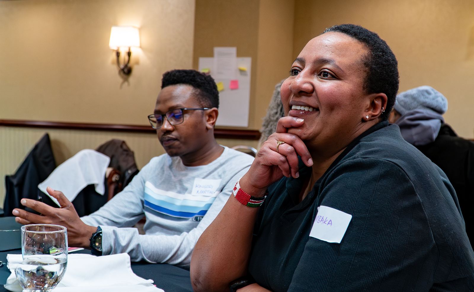 Participants smiling and talking together at a table during the Black History Month Workshop
